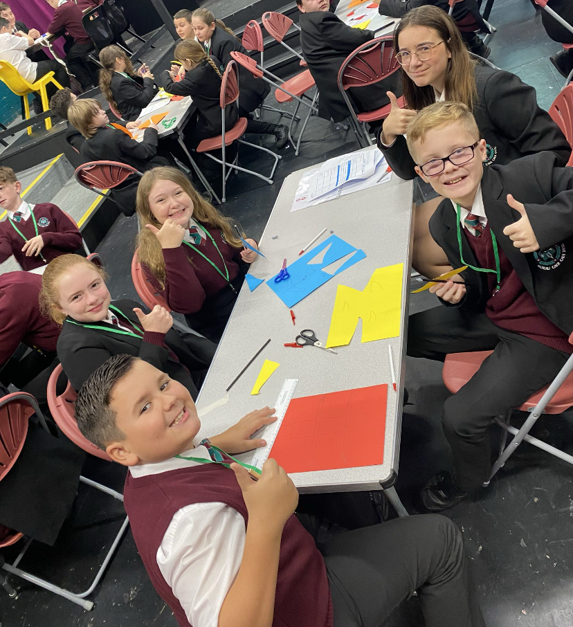 Students start cutting out their aeroplanes using paper.