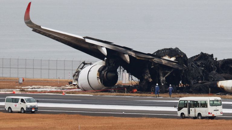 Officials investigate a burnt Japan Airlines (JAL) Airbus A350 plane after a collision with a Japan Coast Guard aircraft at Haneda International Airport in Tokyo, Japan January 3, 2024. REUTERS/Issei Kato/File Photo