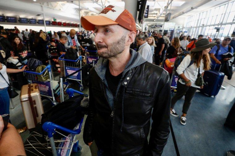 Passenger Larry Reef prepares to check in at Auckland, New Zealand airport for a LATAM Airlines flight to Santiago, Chile, Tuesday, March 12, 2024. LATAM said a flight Monday from Sydney to Auckland experienced ???strong movement??? that injured at least 50 people. Reef was on the flight Monday.(Dean Purcell/New Zealand Herald via AP)